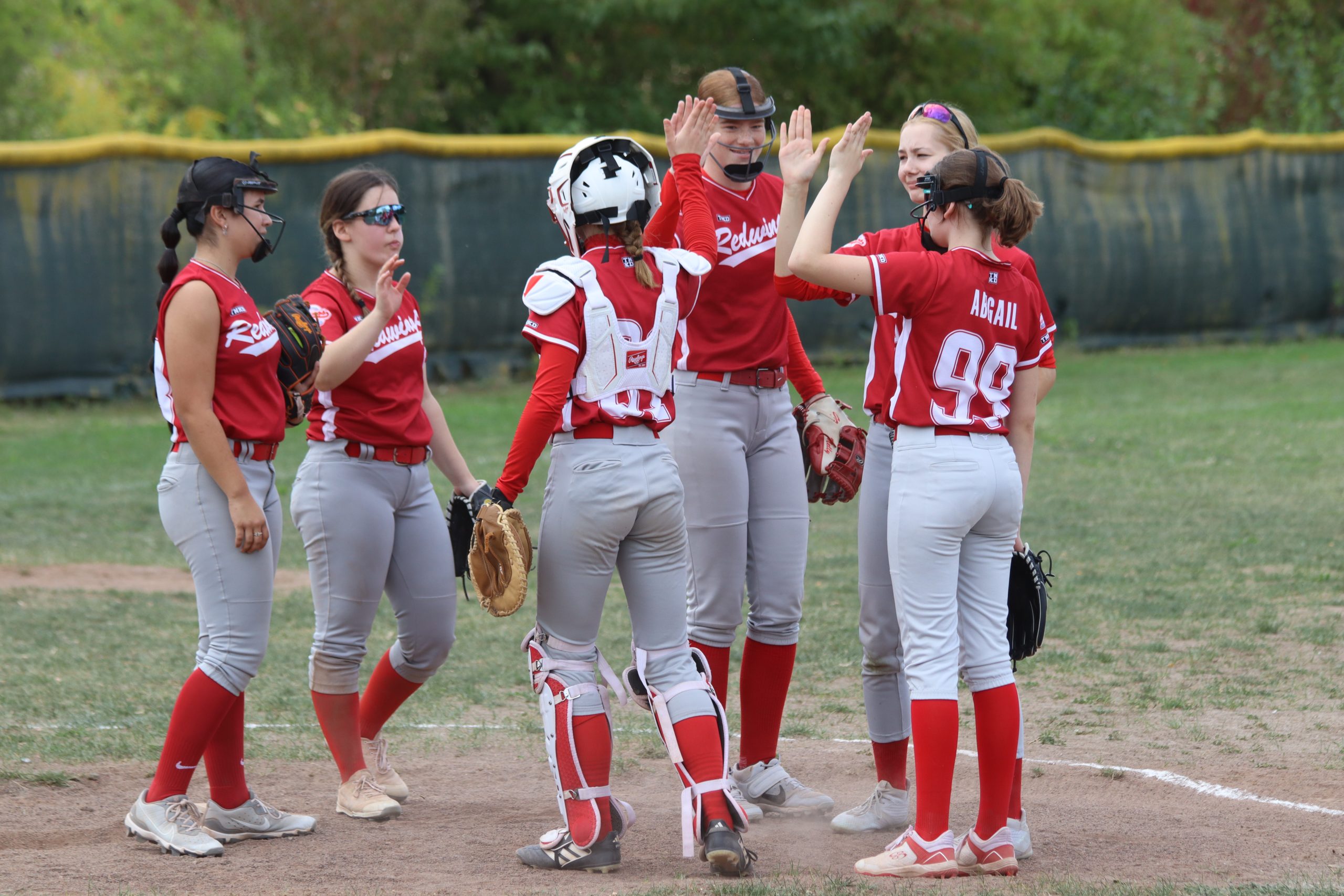 Redwings-Spielerinnen klatschen sich auf dem Feld ab