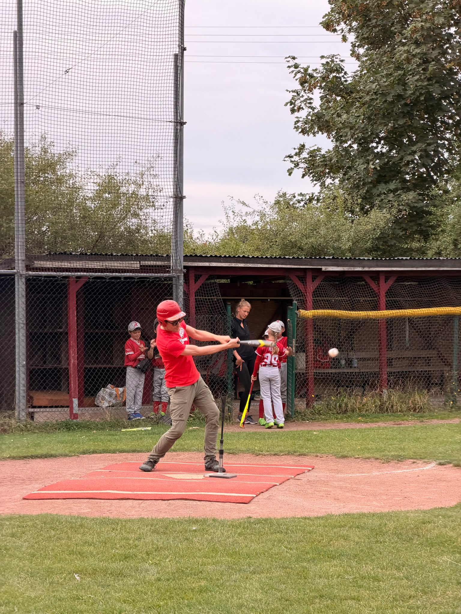 Vater trifft den Ball beim T-Ball-Eltern-Kind-Spiel