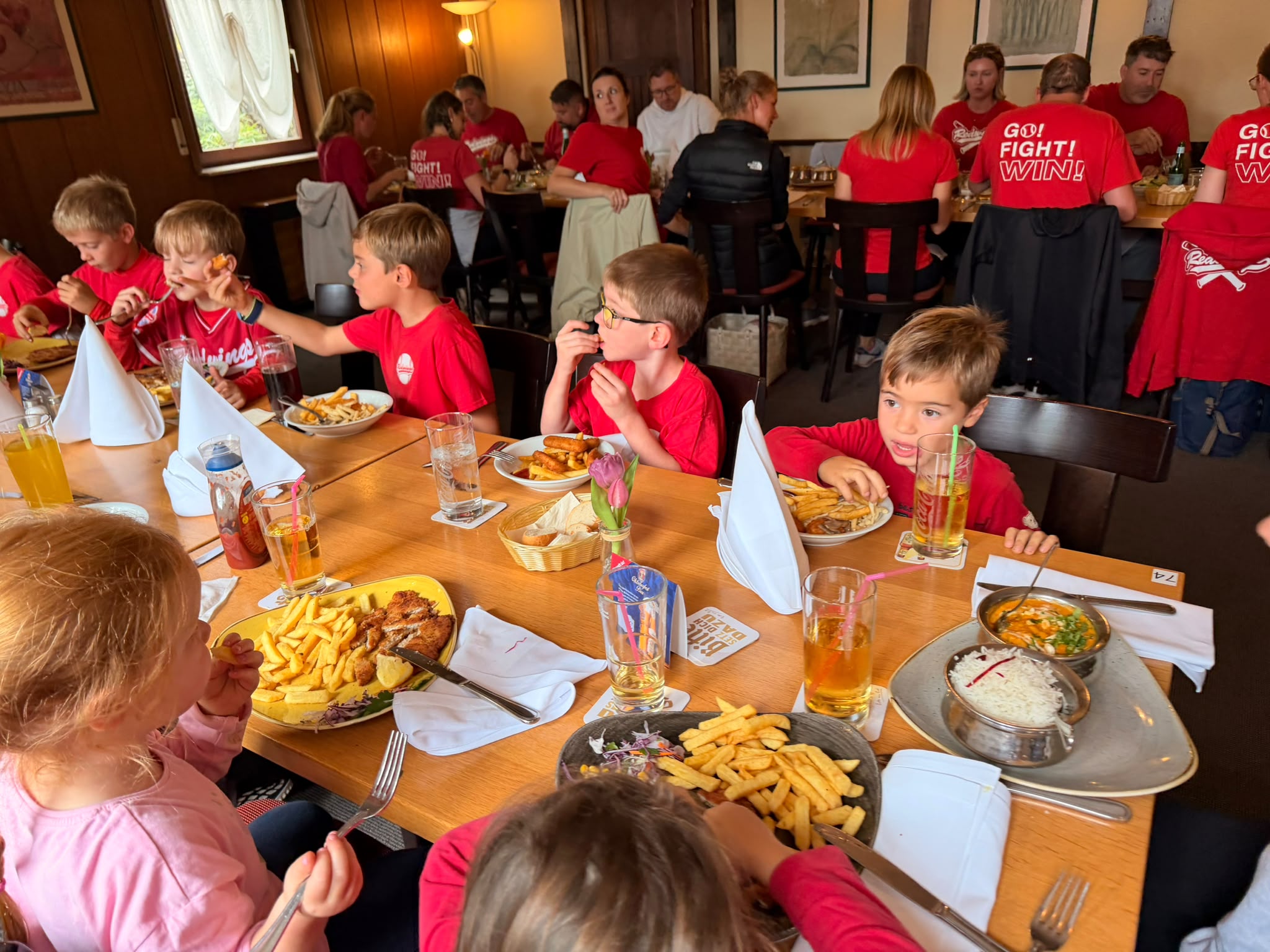 Kinder und Familien beim gemeinsamen Essen zum T-Ball-Saisonabschluss